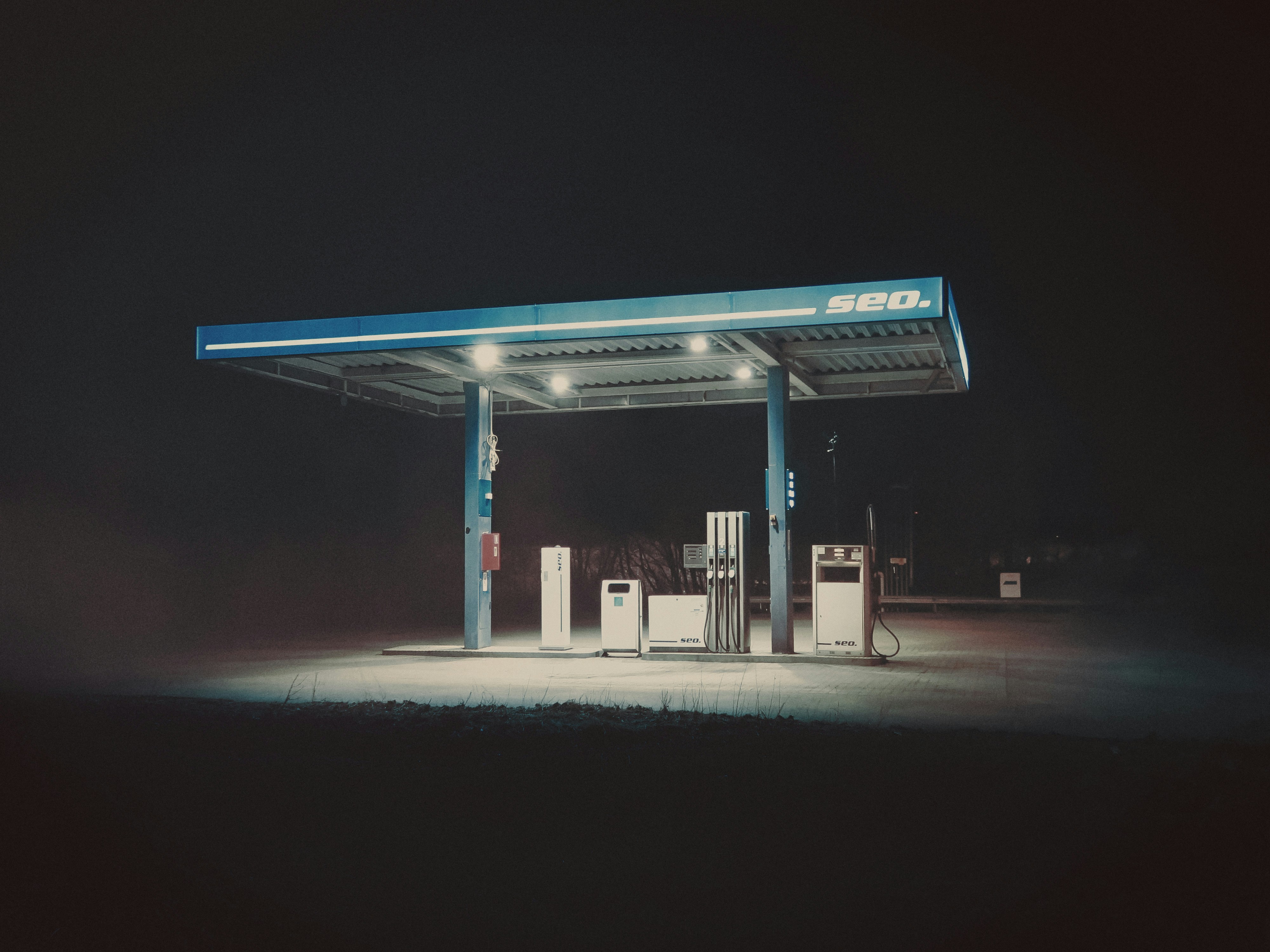 An illuminated gas station canopy at night.